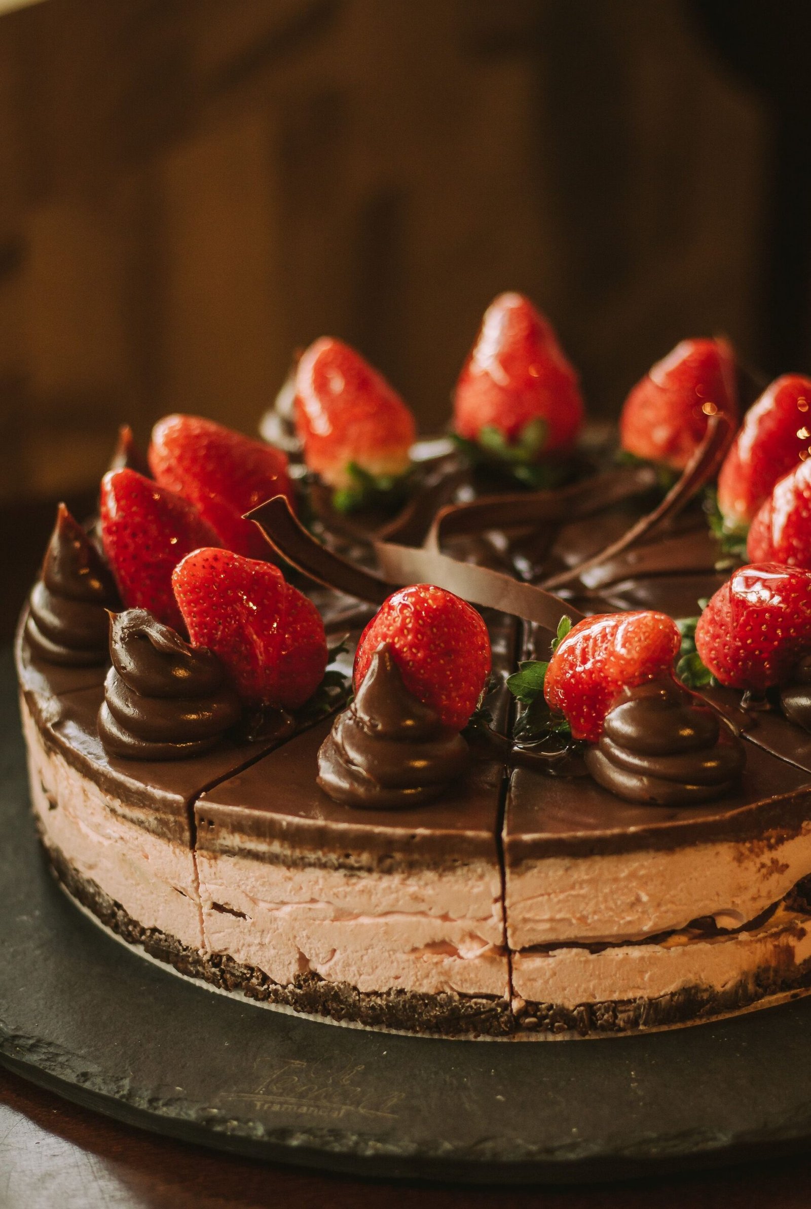 Mouth-watering chocolate cake topped with fresh strawberries and rich chocolate swirls.