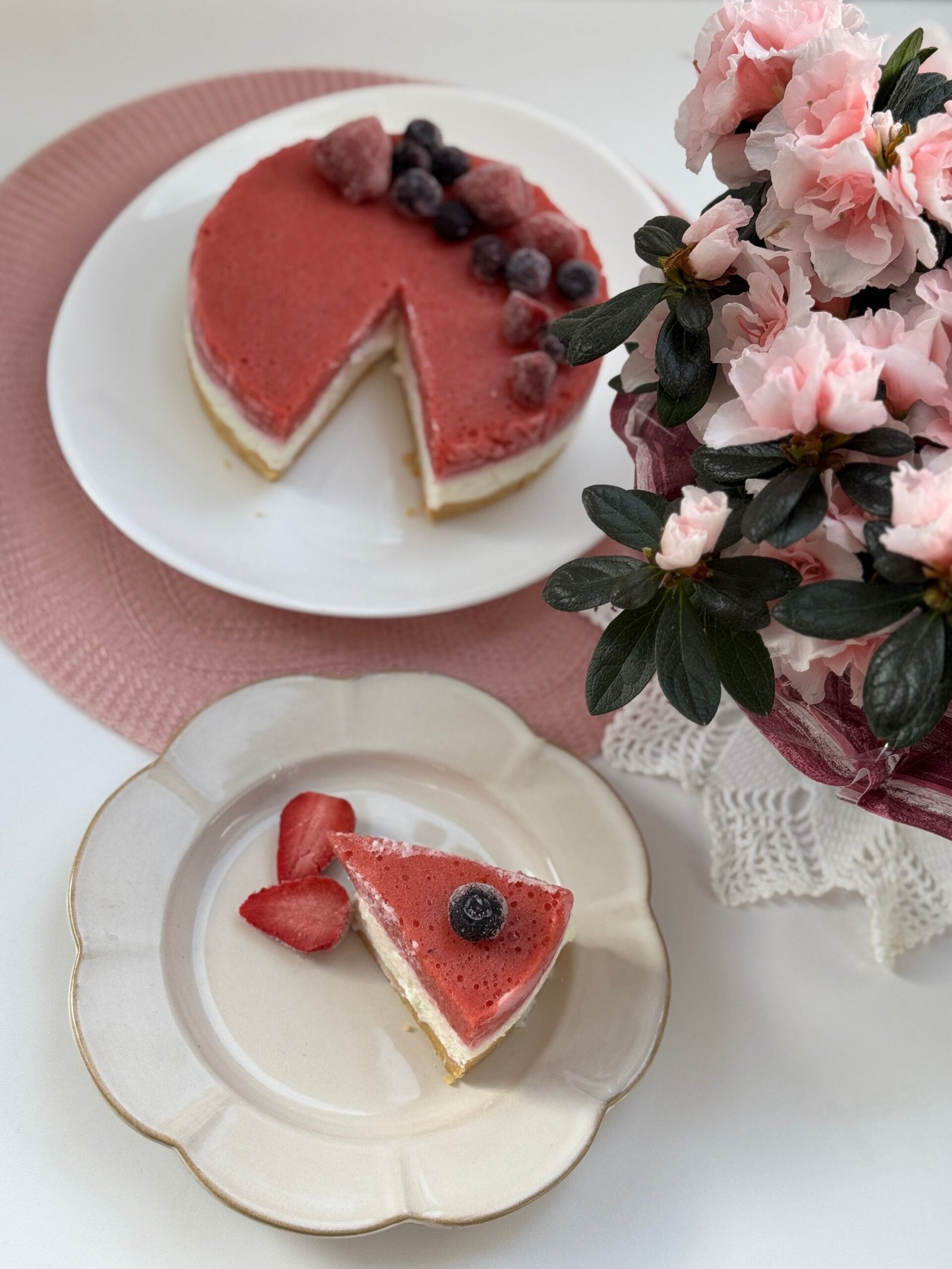 Elegant berry cheesecake and pink flowers creating a perfect aesthetic.